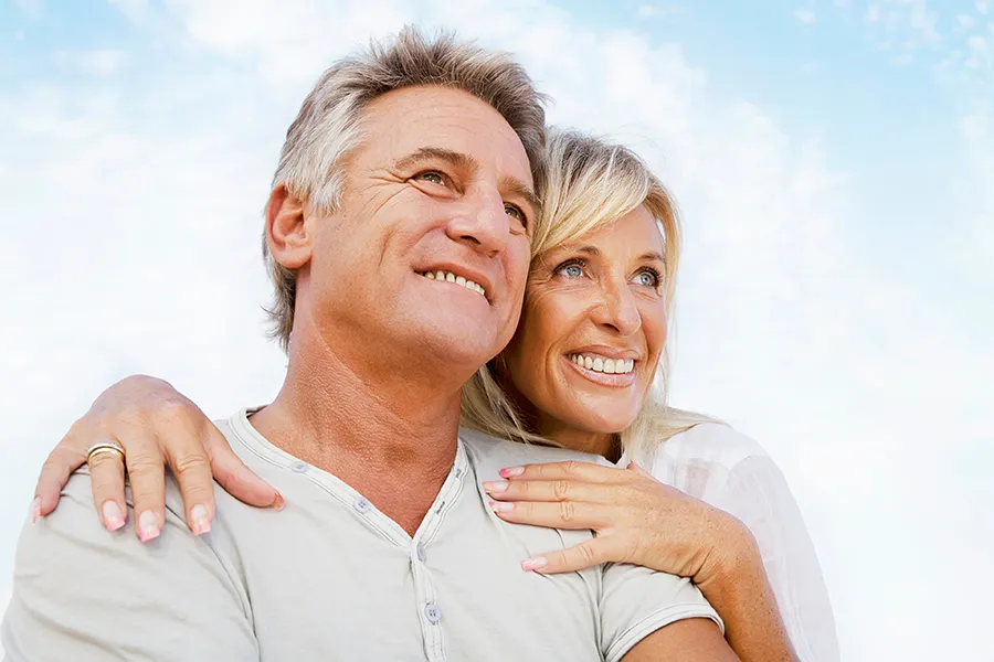 CJC-1295-Peptide-Clinic A mature couple embraces outside under the sky. Get CJC 1295 anti-aging peptides from Better Life Carolinas of Charlotte in Charlotte Metro.