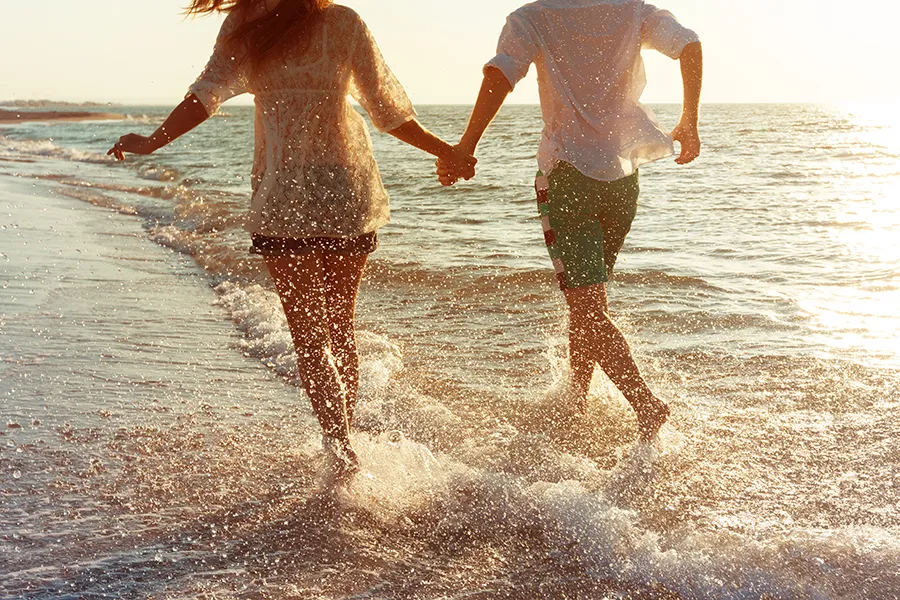 Epithalon-Peptide-Therapy-Clinic A couple run on the beach holding hands. Schedule Epithalon Peptide therapy from Better Life Carolinas of Charlotte in Charlotte Metro.