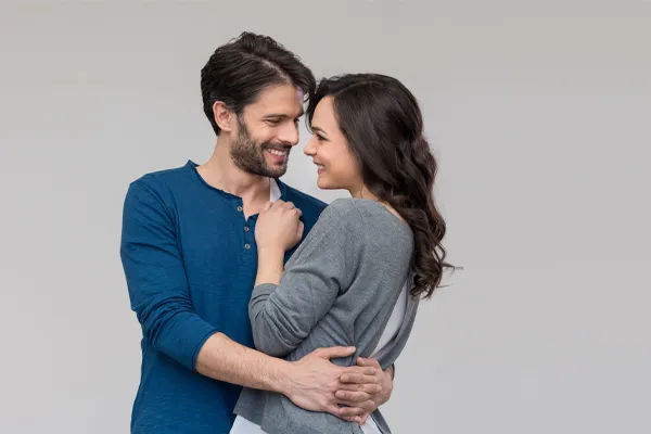 Erectile-Dysfunction-Doctor A man in a blue shirt embracing a woman in a gray shirt smiles due to his successful erectile dysfunction care from Better Life Carolinas of Charlotte in Charlotte Metro.