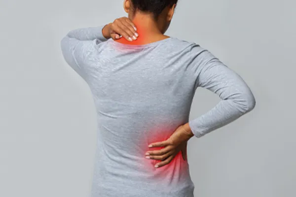 Fibromyalgia-Clinic An image from behind of a woman suffering from Fibromyalgia holding her hands on her neck and lower back. Get fibromyalgia care from Better Life Carolinas of Charlotte in Charlotte Metro.