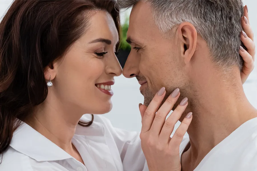 Gainswave-Clinic A middle-aged couple look into each others' eyes and grinning. Get Gainswave treatment for ED from Better Life Carolinas of Charlotte in Charlotte Metro.