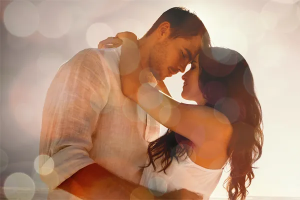 Sexual-Wellness-for-Women-and-Men-Doctor A couple in linen shirts standing in a sparkling light embraces each other with their foreheads touching and eyes closed, happy with their sexual wellness treatments from Better Life Carolinas of Charlotte in Charlotte Metro.
